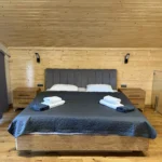 Спальня апартаментів з двоспальним ліжком та дерев'яним декором, Гірська Лаванда