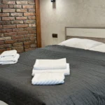 Номер з двоспальним ліжком та цегляною стіною — комплекс Гірська Лаванда